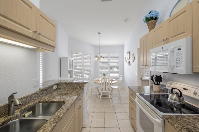 kitchen featuring white appliances, light tile patterned floors, light brown cabinets, an inviting chandelier, and a sink