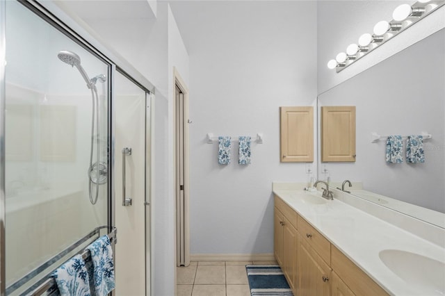 full bath featuring a sink, double vanity, a stall shower, and tile patterned floors