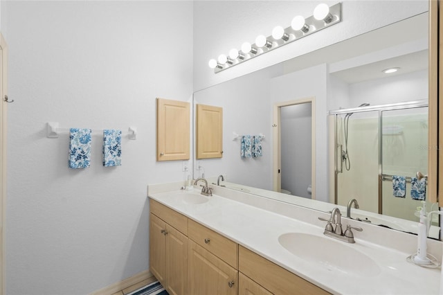 full bathroom with double vanity, a stall shower, toilet, and a sink