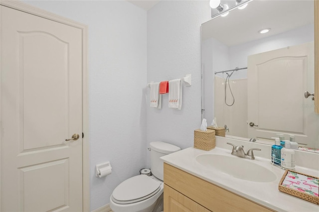 full bathroom with toilet, vanity, and walk in shower