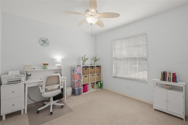 home office featuring light carpet, baseboards, and ceiling fan