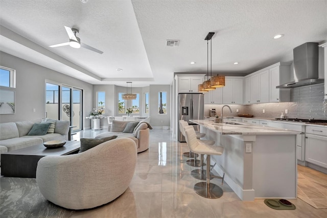 6027 White Mangrove Ln, Bradenton, FL 34210 - kitchen featuring visible vents, open floor plan, decorative backsplash, appliances with stainless steel finishes, and wall chimney exhaust hood