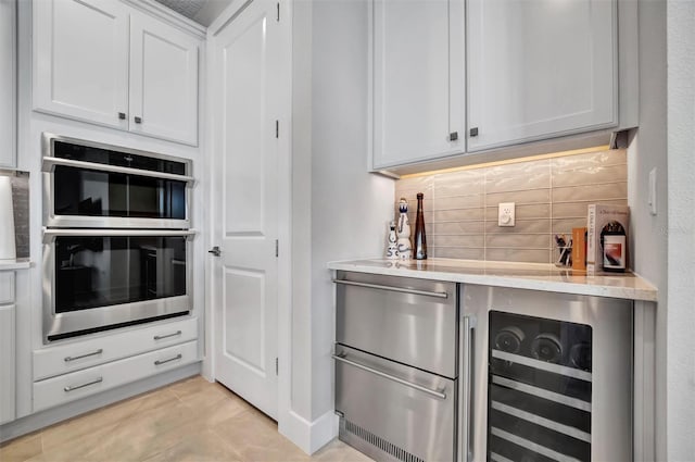 6027 White Mangrove Ln, Bradenton, FL 34210 - kitchen featuring double oven, white cabinets, and tasteful backsplash