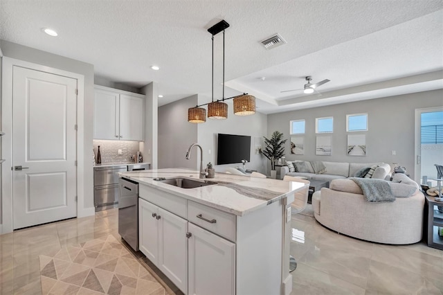 6027 White Mangrove Ln, Bradenton, FL 34210 - kitchen featuring light stone counters, visible vents, a sink, white cabinets, and open floor plan
