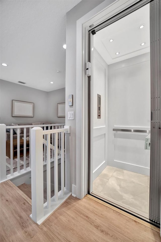 6027 White Mangrove Ln, Bradenton, FL 34210 - interior space with wood finished floors, elevator, an upstairs landing, and recessed lighting