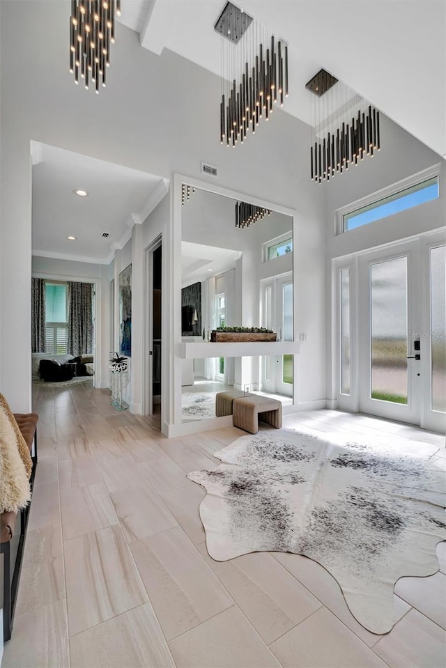 interior space with a chandelier, visible vents, recessed lighting, and a high ceiling