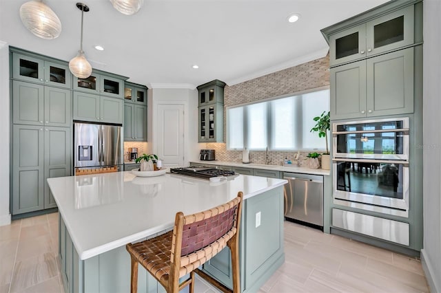 kitchen with a kitchen island, ornamental molding, decorative backsplash, stainless steel appliances, and a warming drawer