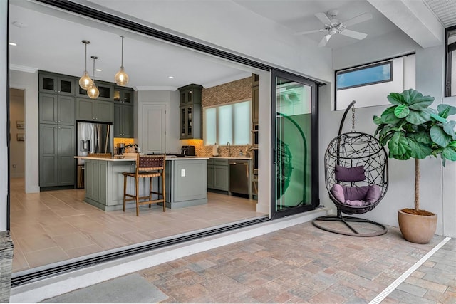 interior space with a center island, a breakfast bar area, light countertops, decorative backsplash, and stainless steel appliances