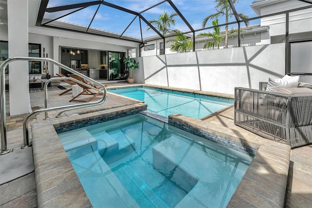 view of pool with glass enclosure, a patio area, and a pool with connected hot tub