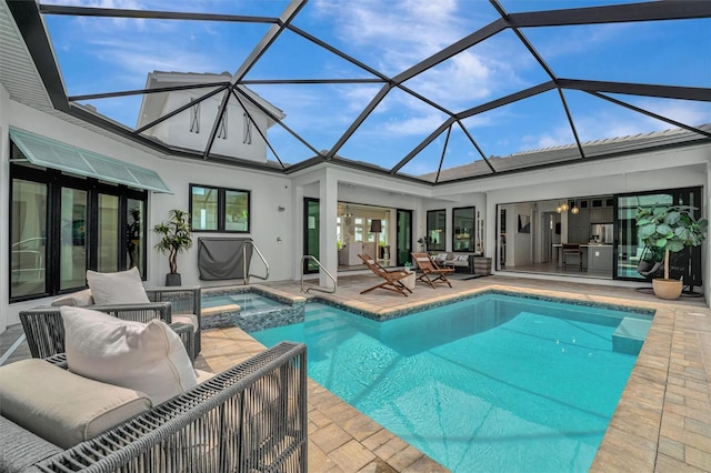 view of swimming pool featuring glass enclosure, a patio, and a pool with connected hot tub