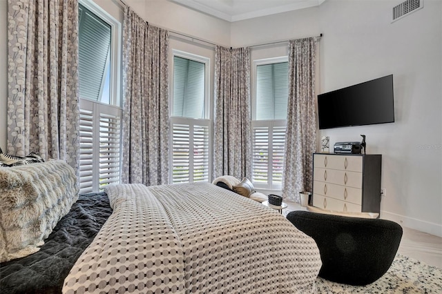 bedroom with visible vents, crown molding, and baseboards