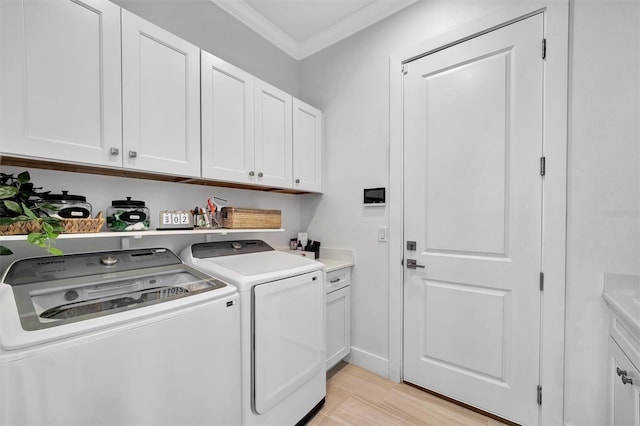 clothes washing area featuring ornamental molding, cabinet space, light wood finished floors, and washing machine and clothes dryer