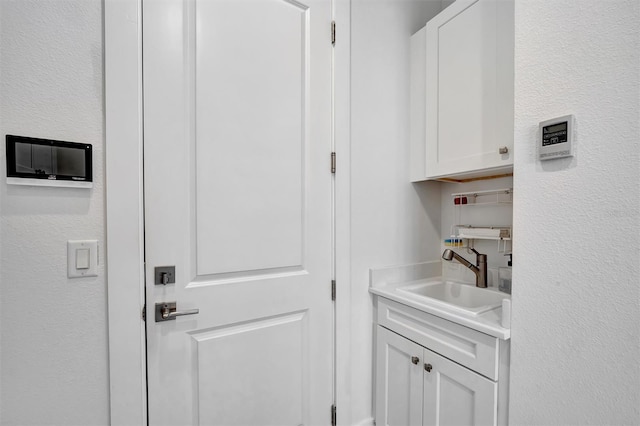 laundry area with a sink and a textured wall