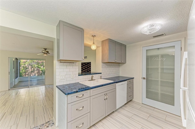 kitchen with tasteful backsplash, visible vents, dishwasher, a ceiling fan, and a sink