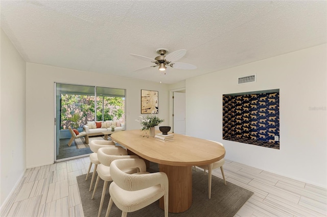 dining room with visible vents, a textured ceiling, and a ceiling fan