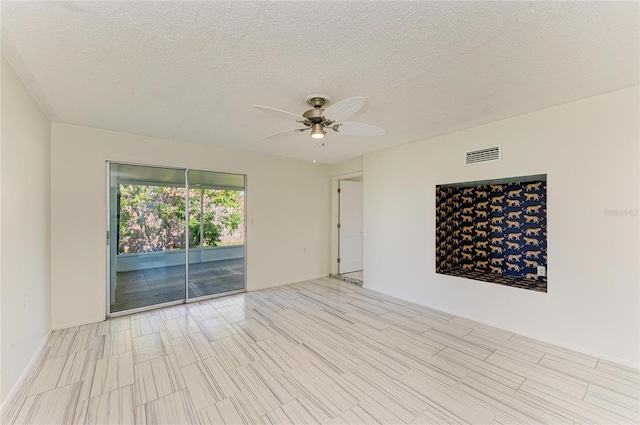 unfurnished room with visible vents, a textured ceiling, and ceiling fan