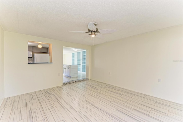 empty room with a textured ceiling and ceiling fan