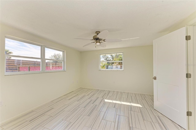 spare room with a ceiling fan and a textured ceiling