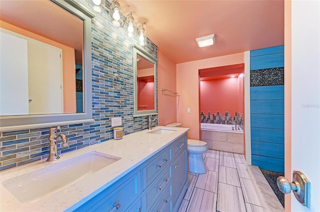 full bath with a sink, a garden tub, tasteful backsplash, and double vanity