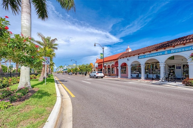 view of road featuring curbs, street lights, and sidewalks