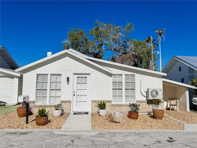 ranch-style house with ac unit and stucco siding