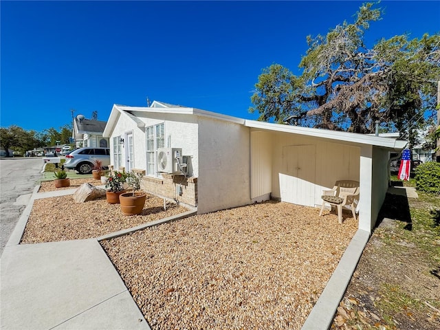 view of side of home with ac unit and stucco siding