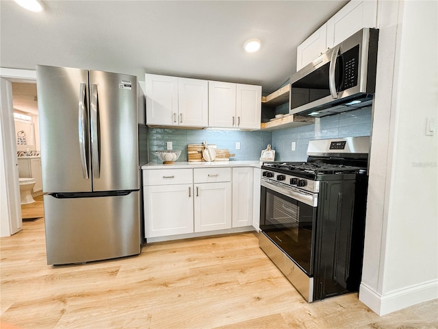 kitchen with light countertops, appliances with stainless steel finishes, white cabinets, and light wood-style floors