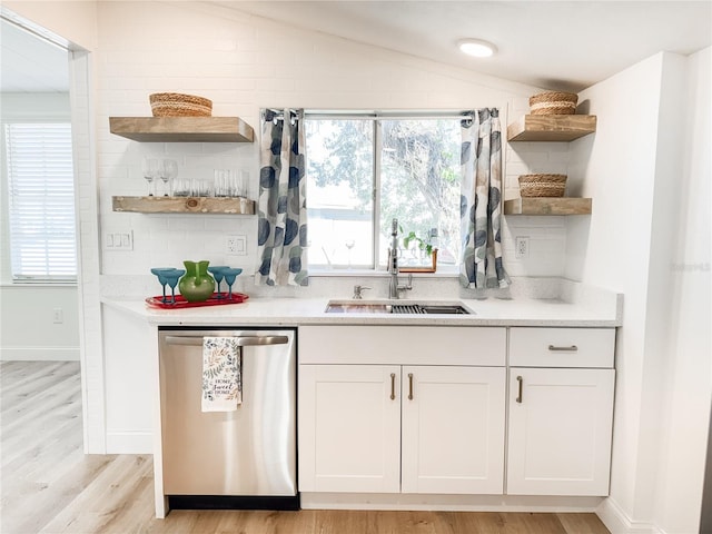 kitchen featuring lofted ceiling, a sink, white cabinetry, stainless steel dishwasher, and open shelves