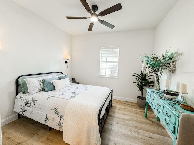 bedroom with ceiling fan, light wood-type flooring, and baseboards