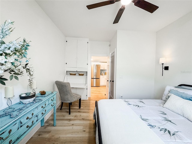 bedroom featuring light wood-type flooring, ceiling fan, and freestanding refrigerator