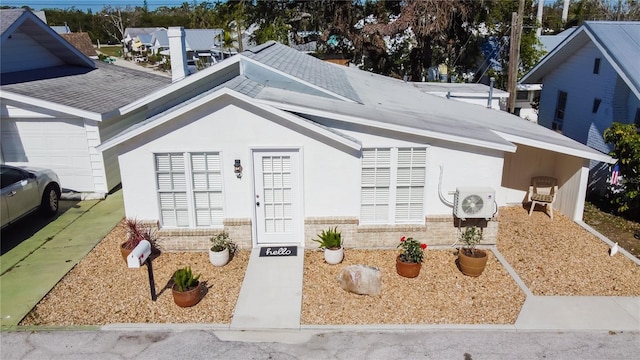 ranch-style house with ac unit, brick siding, and stucco siding