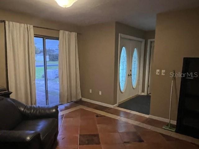 entryway with tile patterned floors and baseboards