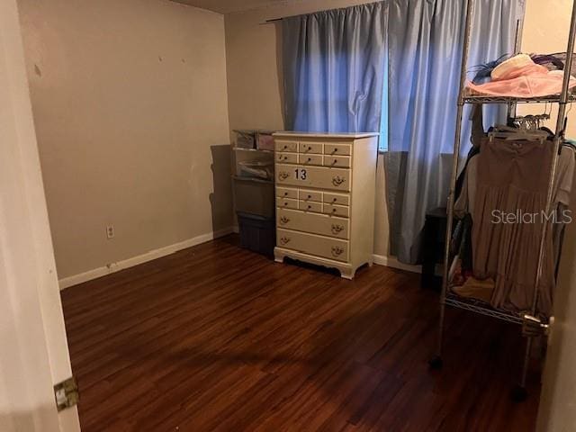 interior space with baseboards and dark wood-style floors