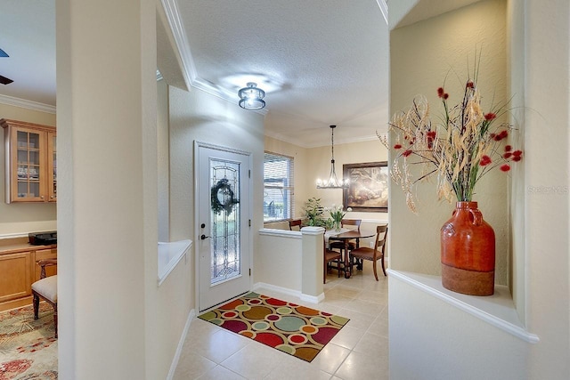 entrance foyer with baseboards, a textured ceiling, ornamental molding, and light tile patterned flooring