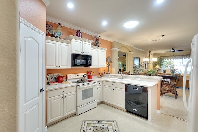 kitchen with crown molding, a peninsula, black appliances, ornate columns, and a sink