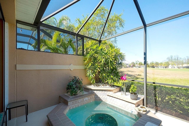 view of pool featuring a patio area, glass enclosure, and a jacuzzi