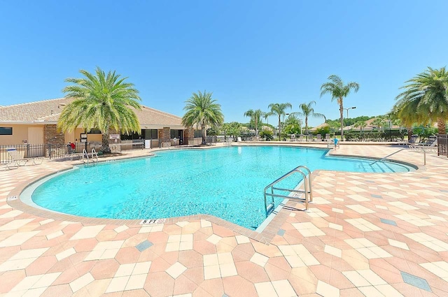 pool featuring fence and a patio area