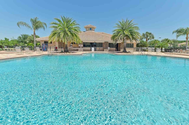 pool featuring fence and a patio area