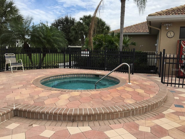 view of swimming pool featuring a patio, fence, and a hot tub