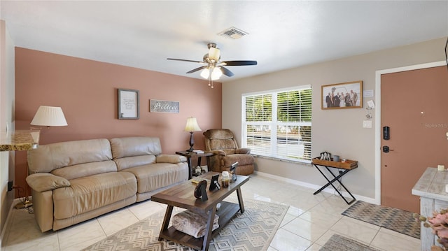 living room featuring a ceiling fan, visible vents, baseboards, and light tile patterned floors