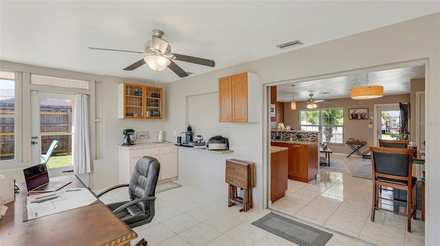 office area featuring light tile patterned floors, ceiling fan, and visible vents