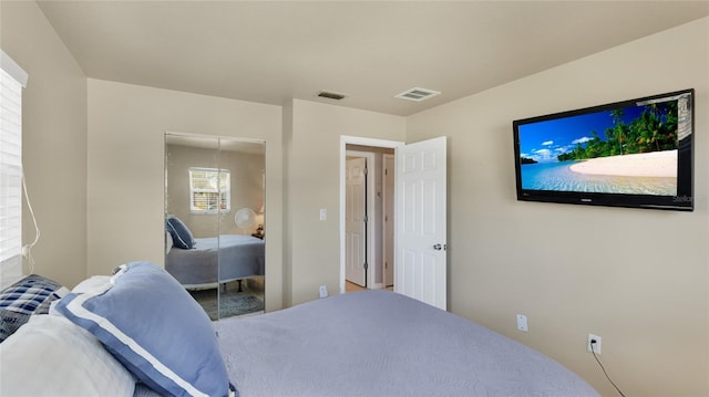 bedroom with a closet and visible vents