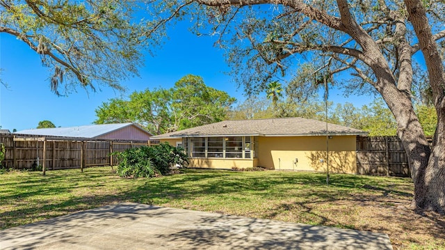 back of property featuring a yard, fence, a sunroom, and stucco siding