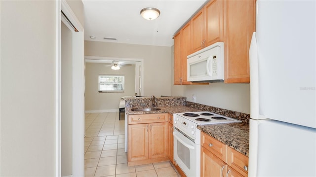 kitchen with light tile patterned floors, visible vents, a sink, dark stone counters, and white appliances