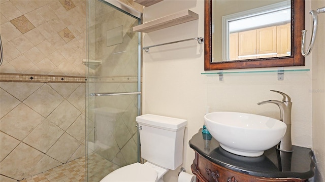 full bathroom with a stall shower, vanity, and toilet