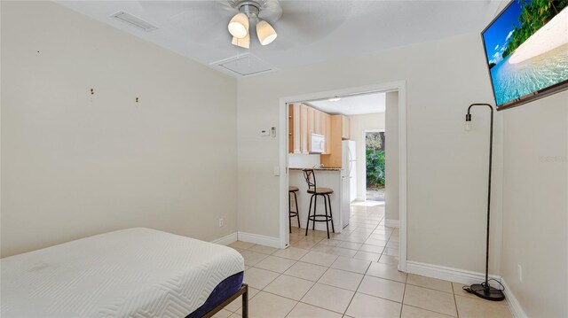 bedroom featuring light tile patterned floors, baseboards, visible vents, and ceiling fan