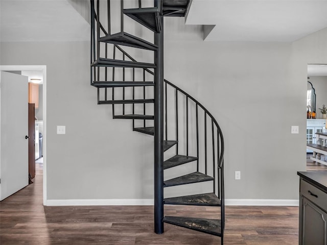 stairway with wood finished floors and baseboards