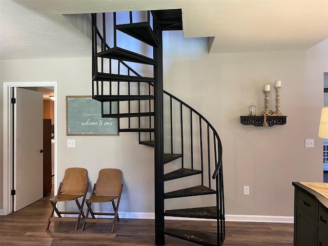 staircase with baseboards and wood finished floors