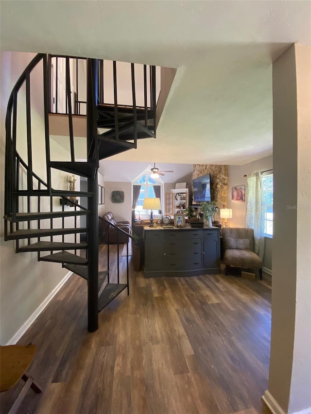 interior space featuring ceiling fan, dark wood finished floors, and baseboards