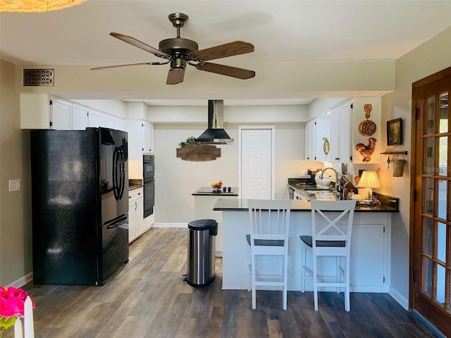 kitchen with a peninsula, visible vents, black appliances, dark countertops, and island exhaust hood